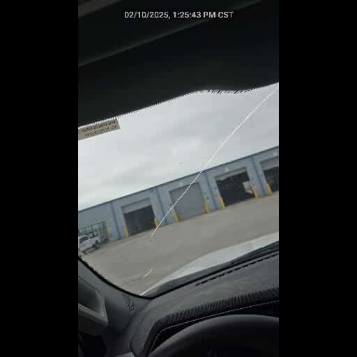 Windscreen with a hairline crack, photographed during a vehicle inspection
